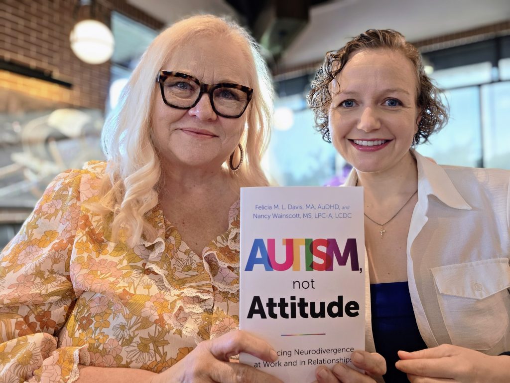 Authors Nancy Wainscott (left) and Felicia M. L. Davis (right) holding a copy of their book "Autism, Not Attitude"